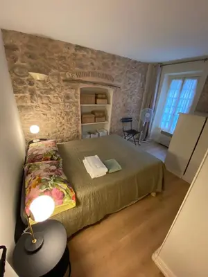 a bedroom with a bed and a stone wall at C054-Bel Appartement Lumineux au Coeur du Suquet in Cannes
