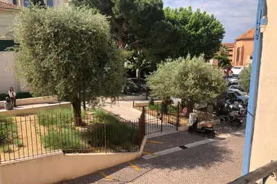 a fence with trees and parked cars on a street at C054-Bel Appartement Lumineux au Coeur du Suquet in Cannes