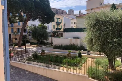 a courtyard with a fence and trees and buildings at C054-Bel Appartement Lumineux au Coeur du Suquet in Cannes