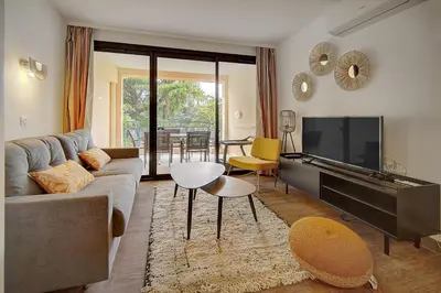 a living room with a couch and a flat screen tv at IMMOGROOM - 3 Rooms - Renovated - Pool - Air conditioning - Parking - Wifi in Cannes