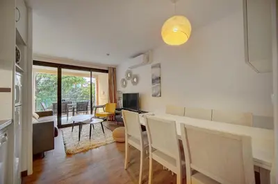 a kitchen and living room with a table and chairs at IMMOGROOM - 3 Rooms - Renovated - Pool - Air conditioning - Parking - Wifi in Cannes