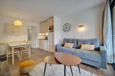 a living room with a blue couch and a table at IMMOGROOM - 3 Rooms - Renovated - Pool - Air conditioning - Parking - Wifi in Cannes