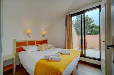 a bedroom with two beds and a large window at IMMOGROOM - 3 Rooms - Renovated - Pool - Air conditioning - Parking - Wifi in Cannes