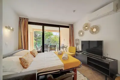 a bedroom with a large bed and a flat screen tv at IMMOGROOM - 3 Rooms - Renovated - Pool - Air conditioning - Parking - Wifi in Cannes
