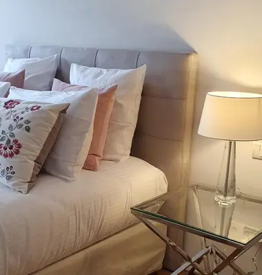 a bed with white pillows and a glass table with a lamp at Villa Terra by Festif Azur - House 250m2 Quiet, 5 min walk from Palais des Festivals and Beaches in Cannes
