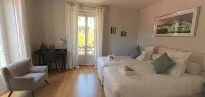 a living room with two beds and a chair at Villa Terra by Festif Azur - House 250m2 Quiet, 5 min walk from Palais des Festivals and Beaches in Cannes