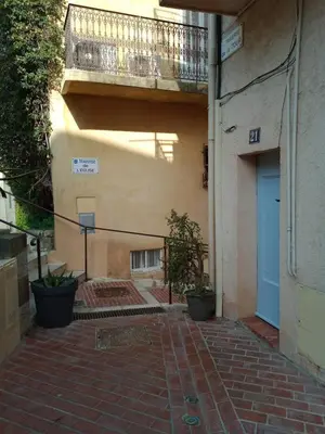 a brick walkway leading to a building with a blue door at Cadre de rêve mais vous faites le ménage- very good prices but you have to clea-n th-e flat in Cannes