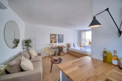 a living room with a couch and a table at IMMOGROOM - Splendid Terrace - Studio - Central in Cannes