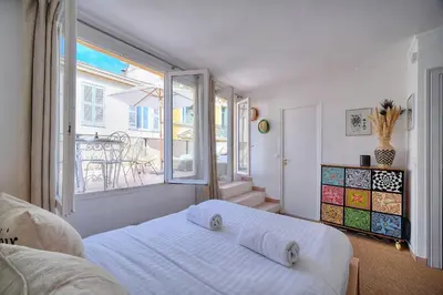 a white bedroom with a bed and a large window at IMMOGROOM - Splendid Terrace - Studio - Central in Cannes
