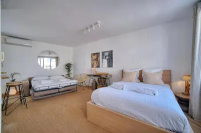 a large bedroom with two beds and a table at IMMOGROOM - Splendid Terrace - Studio - Central in Cannes