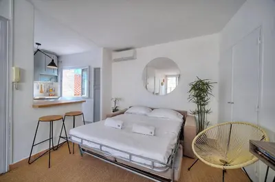 a bedroom with a bed and a table and chairs at IMMOGROOM - Splendid Terrace - Studio - Central in Cannes