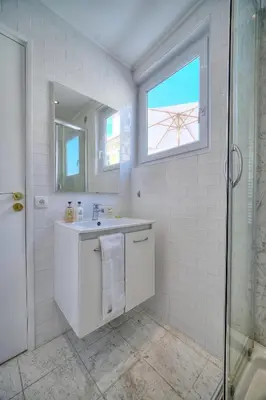 a white bathroom with a sink and a shower at IMMOGROOM - Splendid Terrace - Studio - Central in Cannes