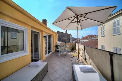 a patio with an umbrella and a table on a balcony at IMMOGROOM - Splendid Terrace - Studio - Central in Cannes