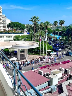 a crowd of people walking around a street with palm trees at Cannes Croisette Superbe 3P front de mer in Cannes
