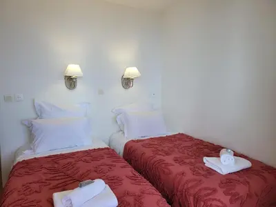 two beds in a hotel room with towels on them at T2 + CABINE VILLA FRANCIA in Cannes