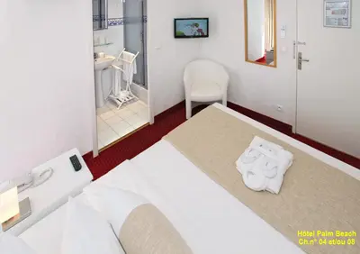 a bedroom with a bed and a bathroom at HOTEL PALM BEACH in Cannes