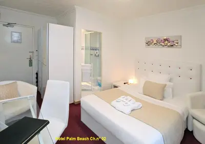 a hotel room with a bed with a towel on it at HOTEL PALM BEACH in Cannes