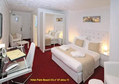 a hotel room with two beds and a desk at HOTEL PALM BEACH in Cannes