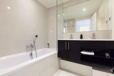 a bathroom with a tub and a sink and a mirror at Modern & cozy 150m from the Croisette in Cannes