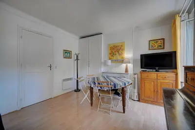 a living room with a table and a television at IMMOGROOM - 5 min from beaches - Suquet - AC in Cannes