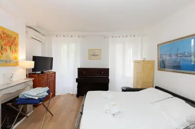 a white bedroom with a bed and a tv at IMMOGROOM - 5 min from beaches - Suquet - AC in Cannes
