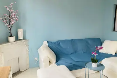 a living room with a blue couch and a table at Grand appartement proche plages & centre ville in Cannes