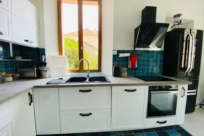 a kitchen with white cabinets and a sink and a window at Grand appartement proche plages & centre ville in Cannes