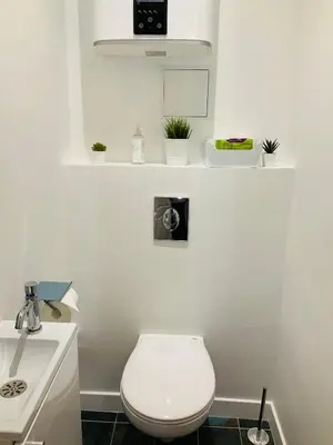 a white bathroom with a toilet and a sink at Grand appartement proche plages & centre ville in Cannes