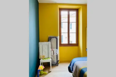 a bedroom with yellow walls and a bed and a window at Grand appartement proche plages & centre ville in Cannes