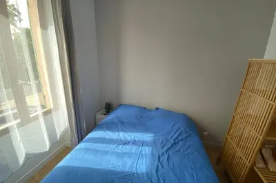 a blue bed in a room with a window at Grand appartement proche plages & centre ville in Cannes
