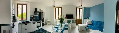 a living room with a blue and white kitchen at Grand appartement proche plages & centre ville in Cannes