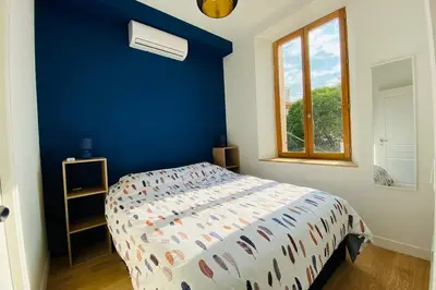 a bedroom with a bed with a blue wall at Grand appartement proche plages & centre ville in Cannes