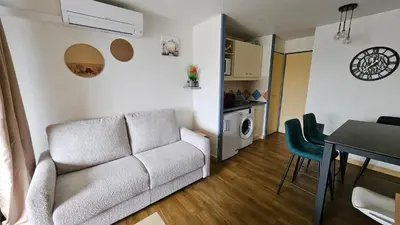 a living room with a couch and a table at Magnifique T2 Climatisation - Grande Terrasse, Piscine et apercu Mer in Cannes