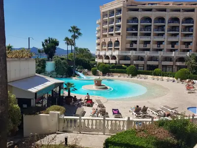a view of a swimming pool with a hotel in the background at Magnifique T2 Climatisation - Grande Terrasse, Piscine et apercu Mer in Cannes