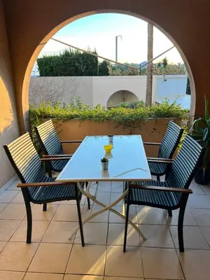 a table and chairs on a patio with a view at Magnifique T2 Climatisation - Grande Terrasse, Piscine et apercu Mer in Cannes