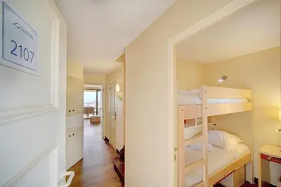 a small room with a bunk bed and a hallway at IMMOGROOM - 2BR - sea view - Swimming pool - Terrace - Parking - AC - Wifi in Cannes