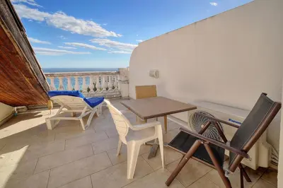 a balcony with a table and chairs and a view of the ocean at IMMOGROOM - 2BR - sea view - Swimming pool - Terrace - Parking - AC - Wifi in Cannes