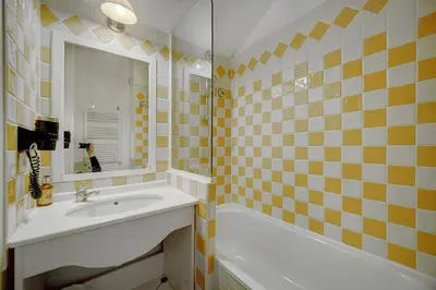 a bathroom with a sink and a tub and a mirror at IMMOGROOM - 2BR - sea view - Swimming pool - Terrace - Parking - AC - Wifi in Cannes