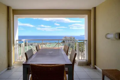 a balcony with a table and a view of the ocean at IMMOGROOM - 2BR - sea view - Swimming pool - Terrace - Parking - AC - Wifi in Cannes