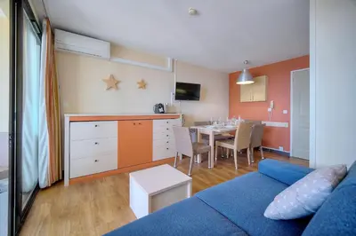 a living room with a blue couch and a dining room at IMMOGROOM - 2BR - sea view - Swimming pool - Terrace - Parking - AC - Wifi in Cannes