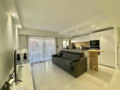 a living room with a couch and a kitchen at Branly 4, by Welcome to Cannes in Cannes