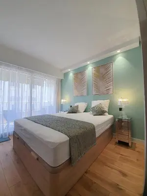 a bedroom with a large bed with green walls at Branly 4, by Welcome to Cannes in Cannes