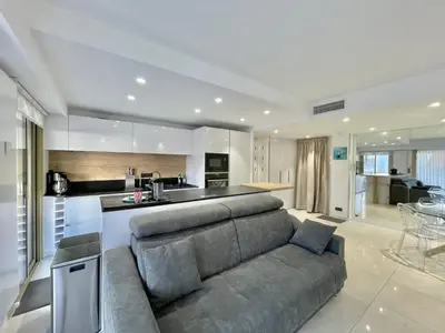 a living room with a couch and a kitchen at Branly 4, by Welcome to Cannes in Cannes