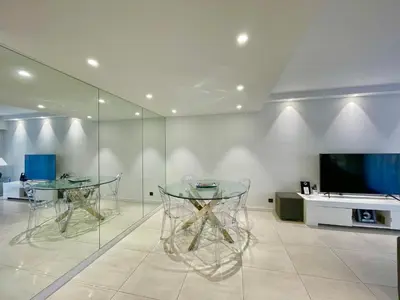 two glass tables in a room with a tv at Branly 4, by Welcome to Cannes in Cannes