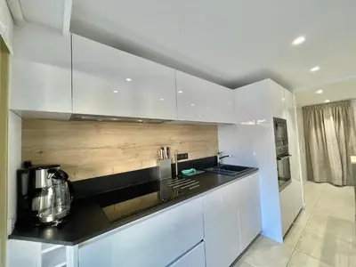 a kitchen with white cabinets and a black counter top at Branly 4, by Welcome to Cannes in Cannes