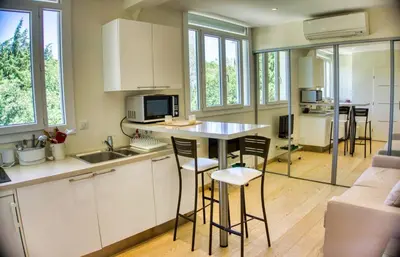 a kitchen with a counter and chairs in a room at Cannes charming studio 50 meters from the beach !! in Cannes