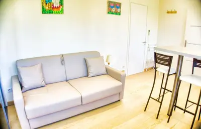 a living room with a couch and a table at Cannes charming studio 50 meters from the beach !! in Cannes