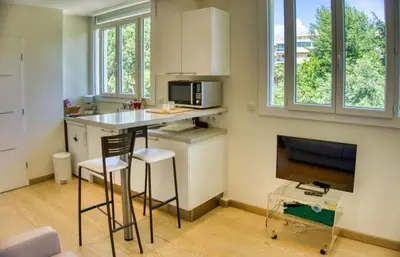 a small kitchen with a table and a television at Cannes charming studio 50 meters from the beach !! in Cannes