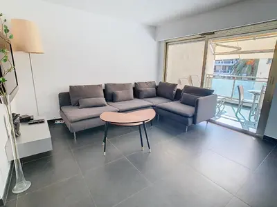 a living room with a couch and a table at Appartements de Standing Cannes Centre in Cannes