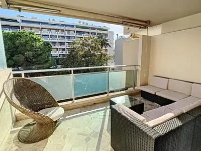 a balcony with a couch and a glass table at Appartements de Standing Cannes Centre in Cannes